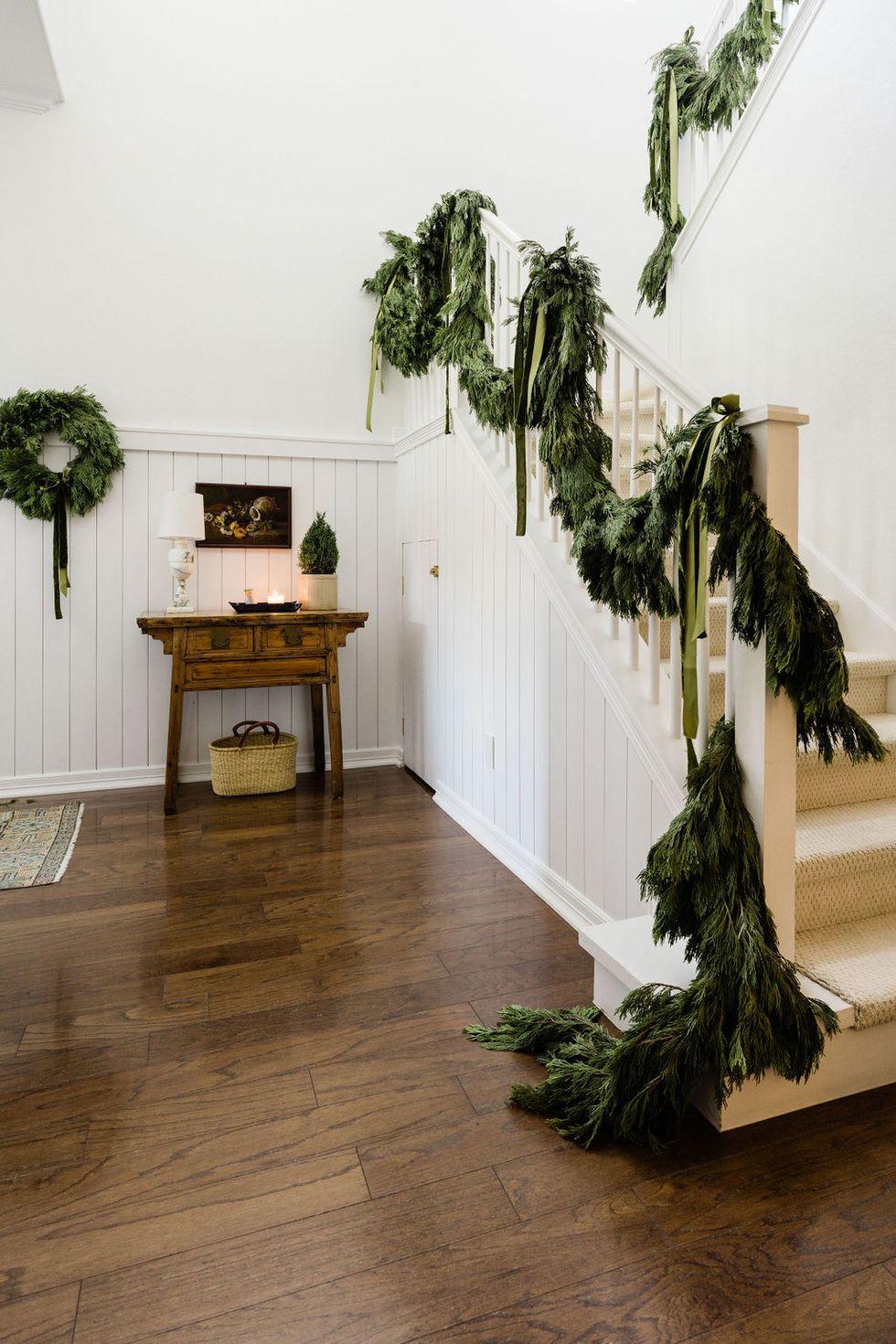 Garland hung on the banister with velvet ribbon  Velvet christmas bow,  Magnolia leaf garland, Christmas banister