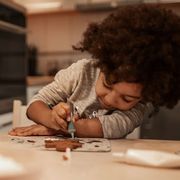 little girl decorating gingerbread cookie