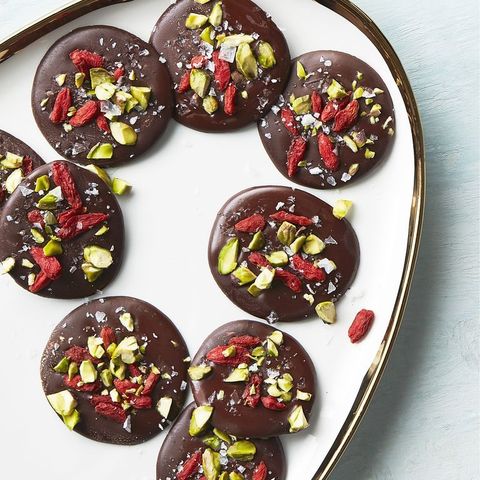 chocolate coins with dried fruits and nuts sprinkled on top