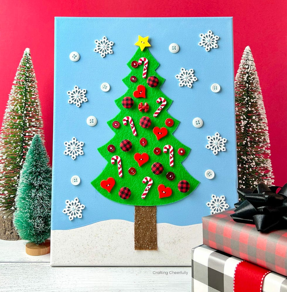 craft display of a decorated christmas tree on a blue background with snowflakes