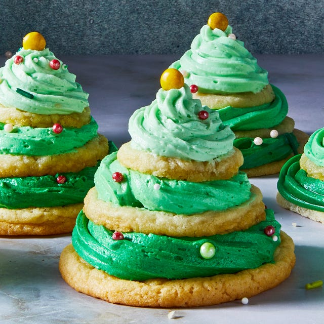 sugar cookies stacked with green icing and sprinkles to make christmas tree stacks