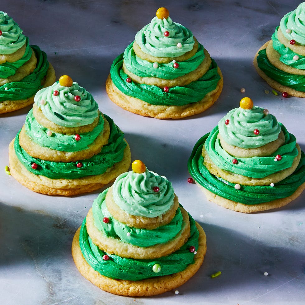 sugar cookies stacked with green icing and sprinkles to make christmas tree stacks