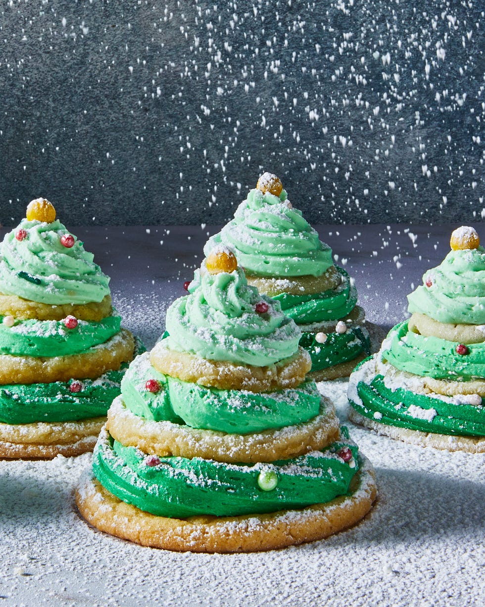 sugar cookies stacked with green icing and sprinkles to make christmas tree stacks