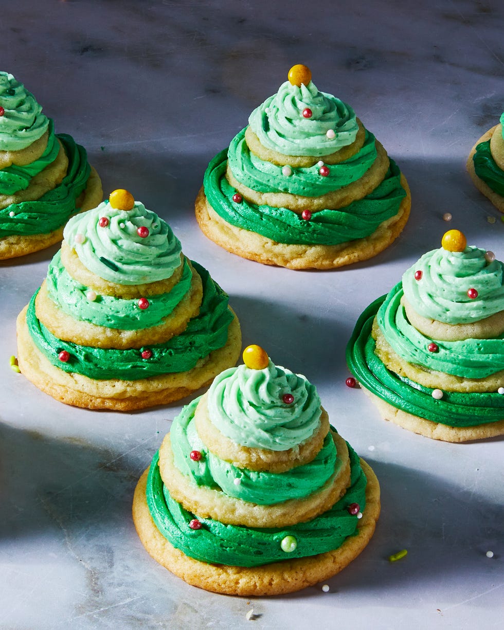 sugar cookies stacked with green icing and sprinkles to make christmas tree stacks