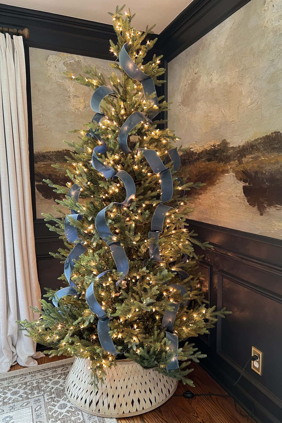 a tree with lights and blue ribbon