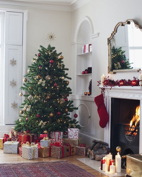 christmas tree surrounded with gifts near fireplace