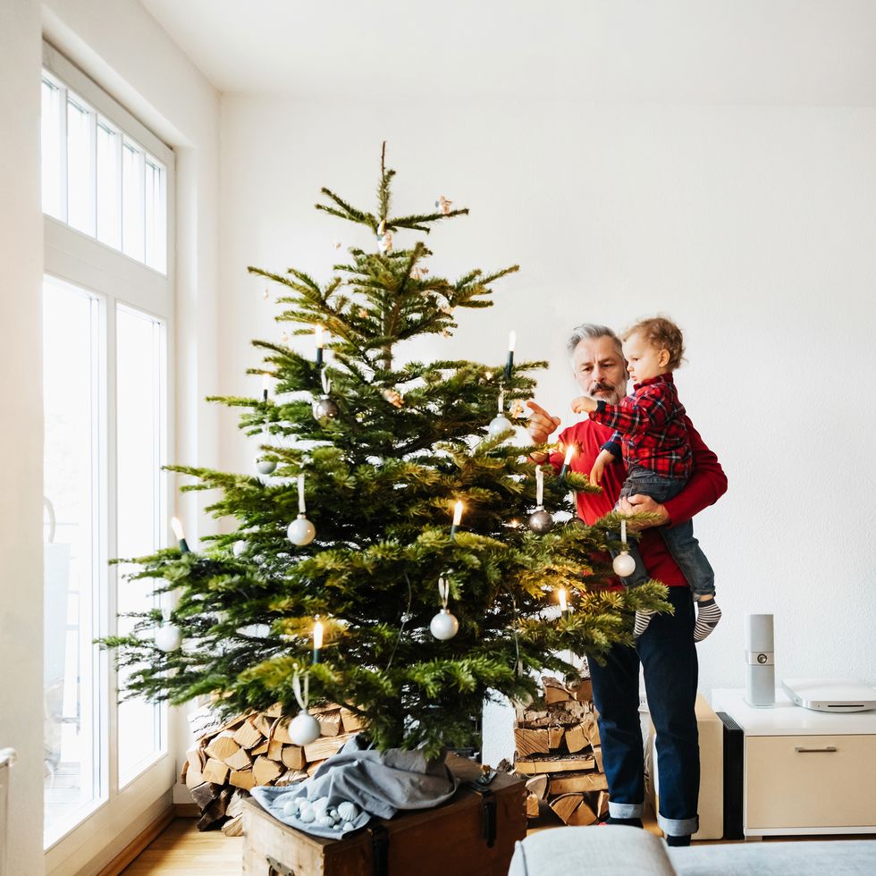grandpa decorating christmas tree with grandson