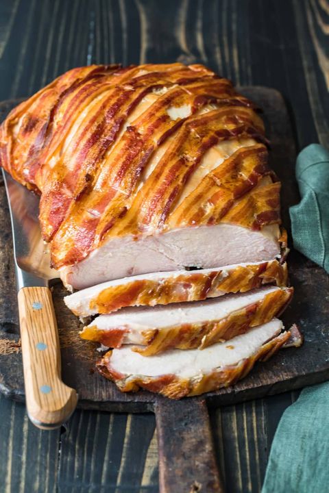 bacon wrapped turkey breast on wood board