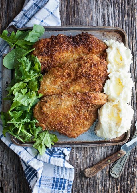 crispy pan fried parmesan turkey cutlets on tray with lettuce and mashed potatoes