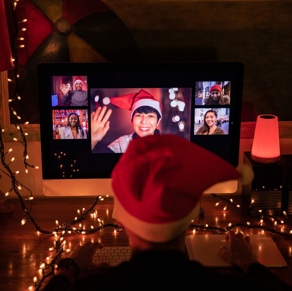 man in front of computer in video call with friends and relatives in christmas time