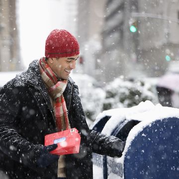 a person in a red hat and coat holding a red book