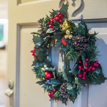 christmas wreath hung on front door with door ajar