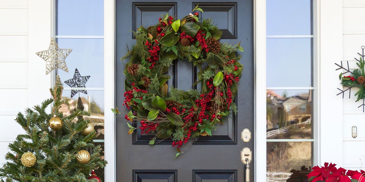 christmas wreath on front door, poinsettia and tree on stoop
