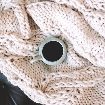 coffee mug on top of chunky knit throw blanket