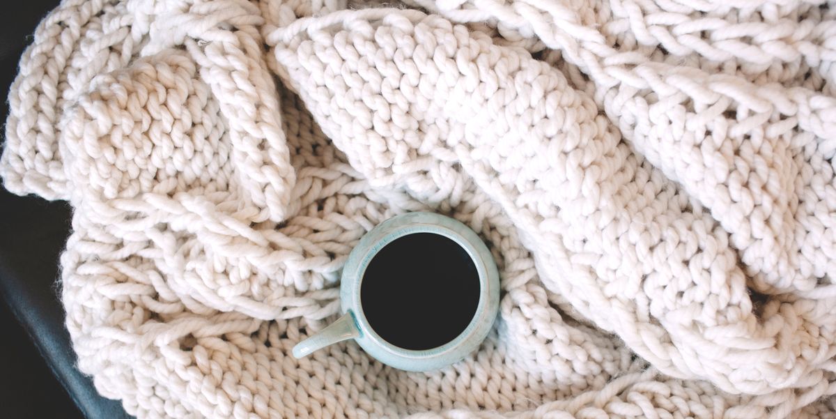 coffee mug on top of chunky knit throw blanket