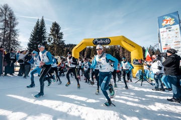 participants in a snow running event starting under an archway