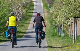 dos ciclistas pedalean junto a un campo de flores en alemania