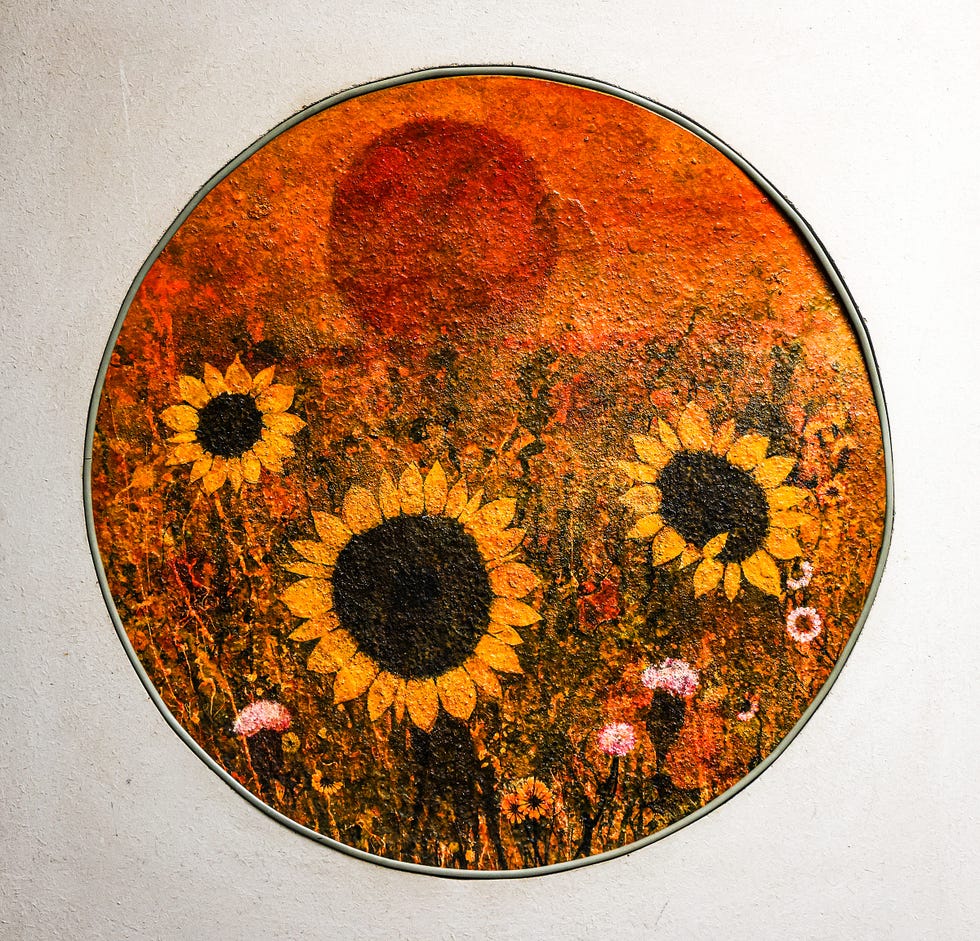 artistic depiction of sunflowers under a warm orangehued sky