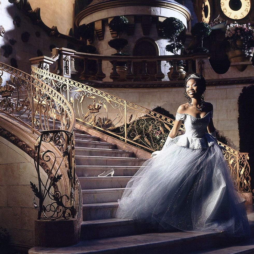 a gownclad figure descending a grand staircase in an opulent setting