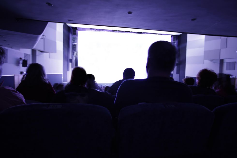 group of people looking at clear white screen at cinema