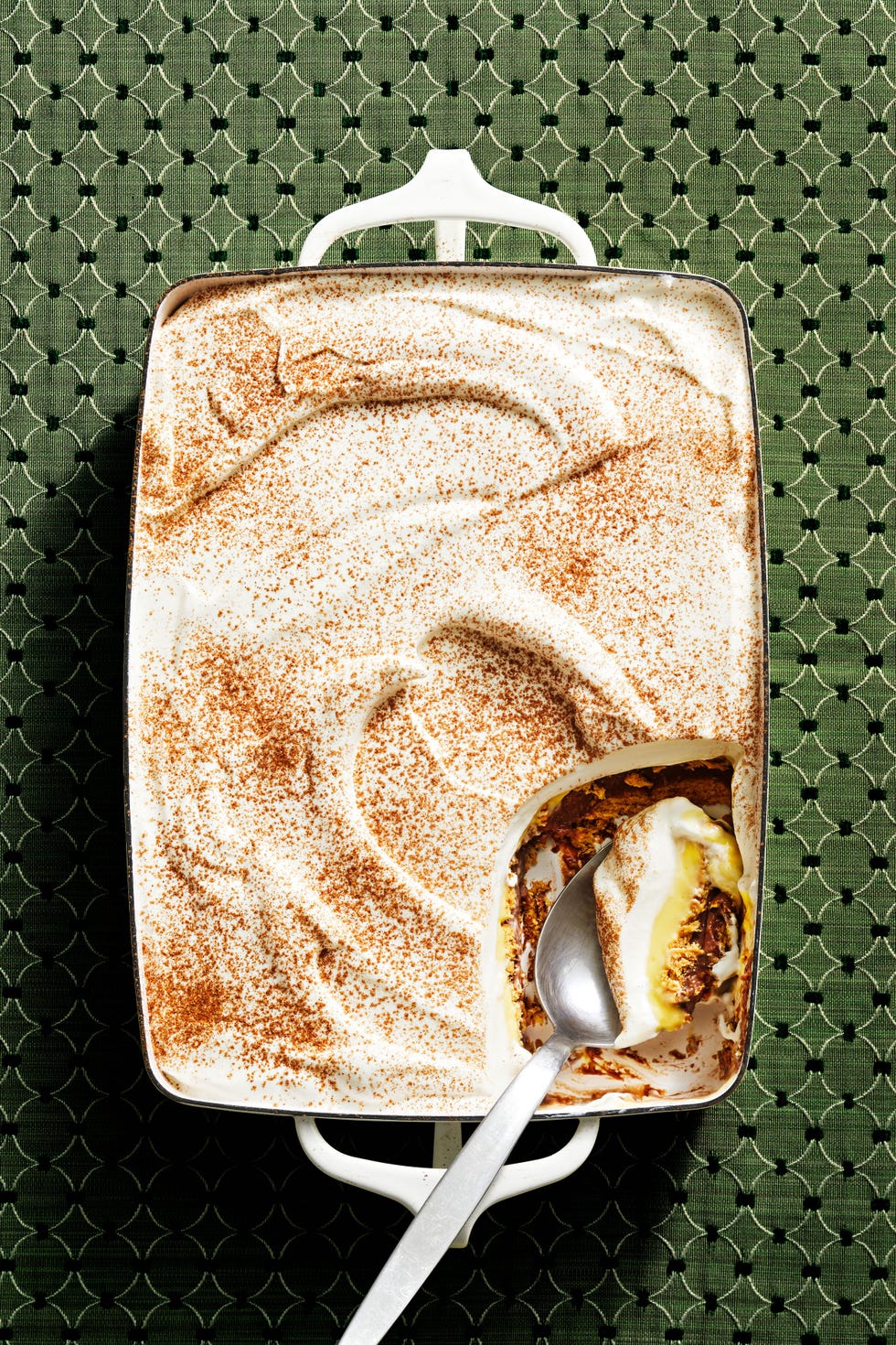 a spoon scooping out of a cinnamon dusted icebox cake