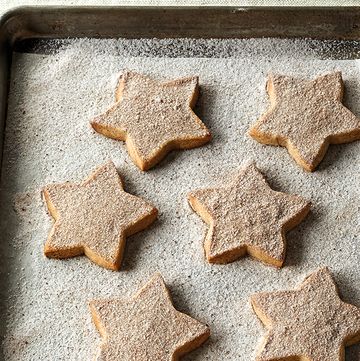 ina garten's cinnamonspiced shortbread shaped like stars on a baking sheet covered in sugar