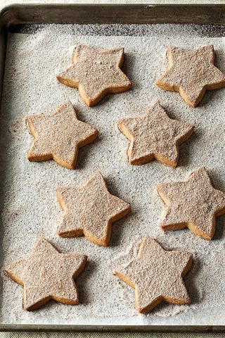 ina garten's cinnamonspiced shortbread shaped like stars on a baking sheet covered in sugar