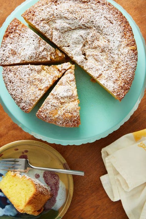 citrus olive oil cake on a teal cake stand with a slice on a plate nearby