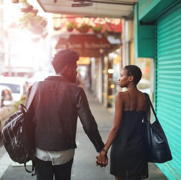 Questions for Couples a couple from the back holding hands in a sun dappled city