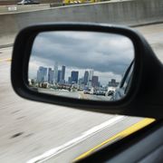 city skyline in the driving mirror