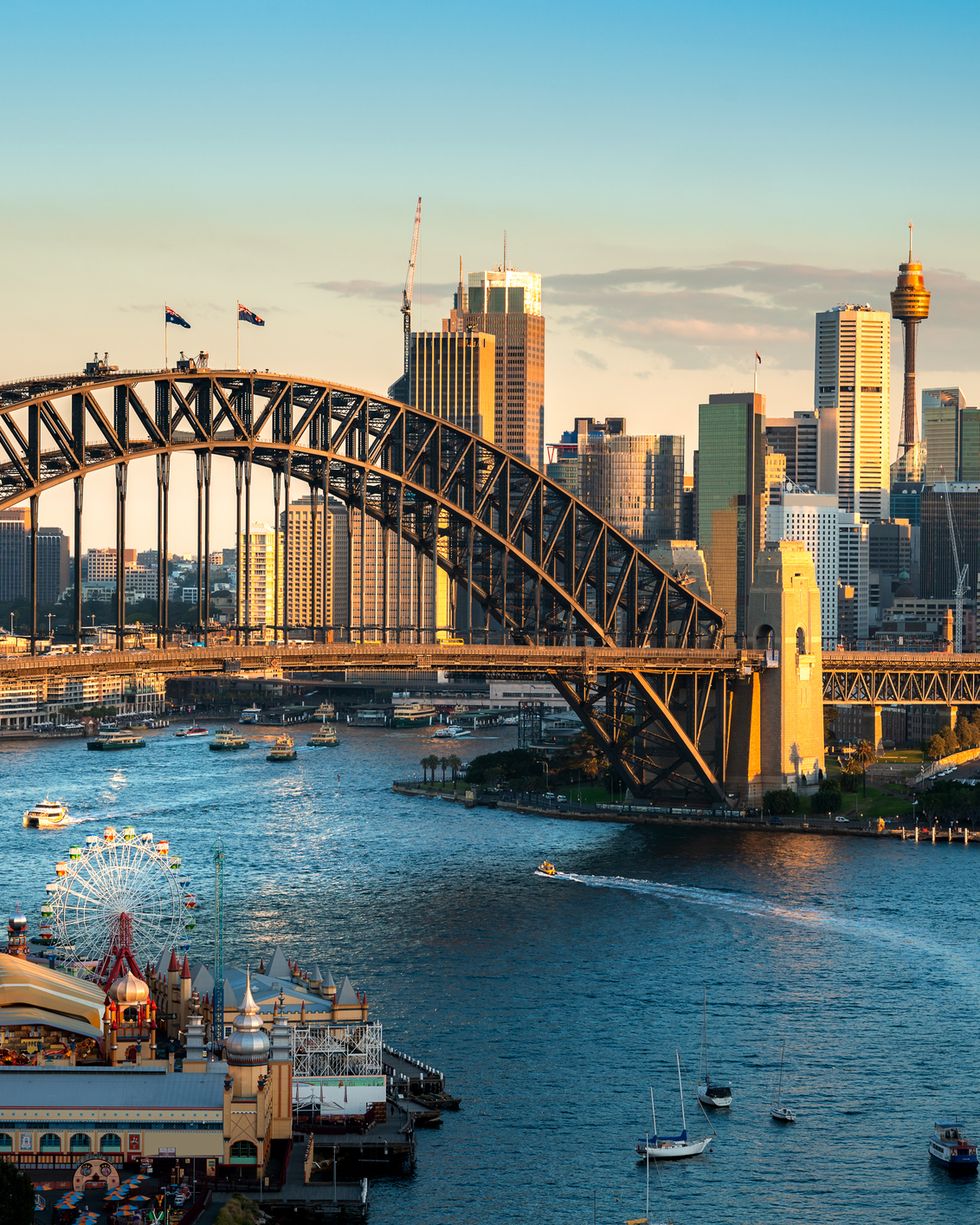 cityscape image of sydney, australia with harbor bridge and sydney skyline during sunset vacation and travel in australia