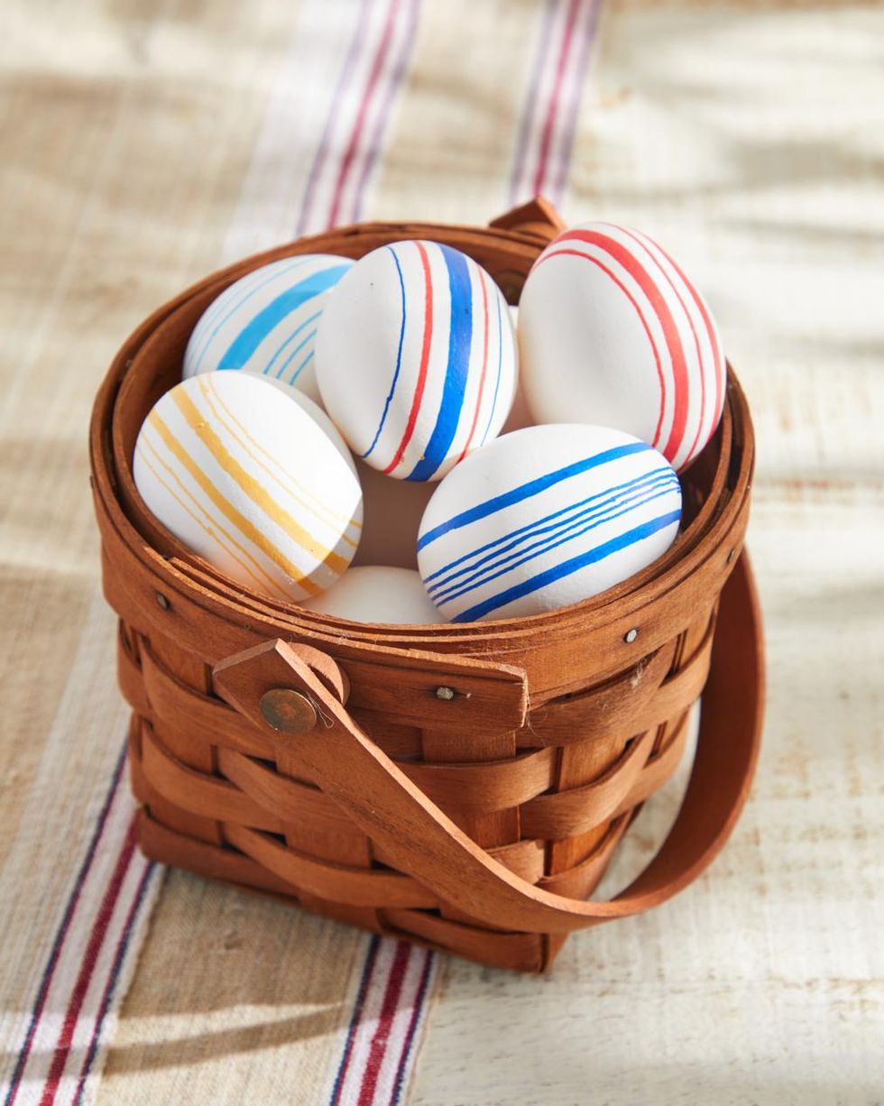 easter eggs decorated to look like vintage grain sack with striped on them set in an easter basket