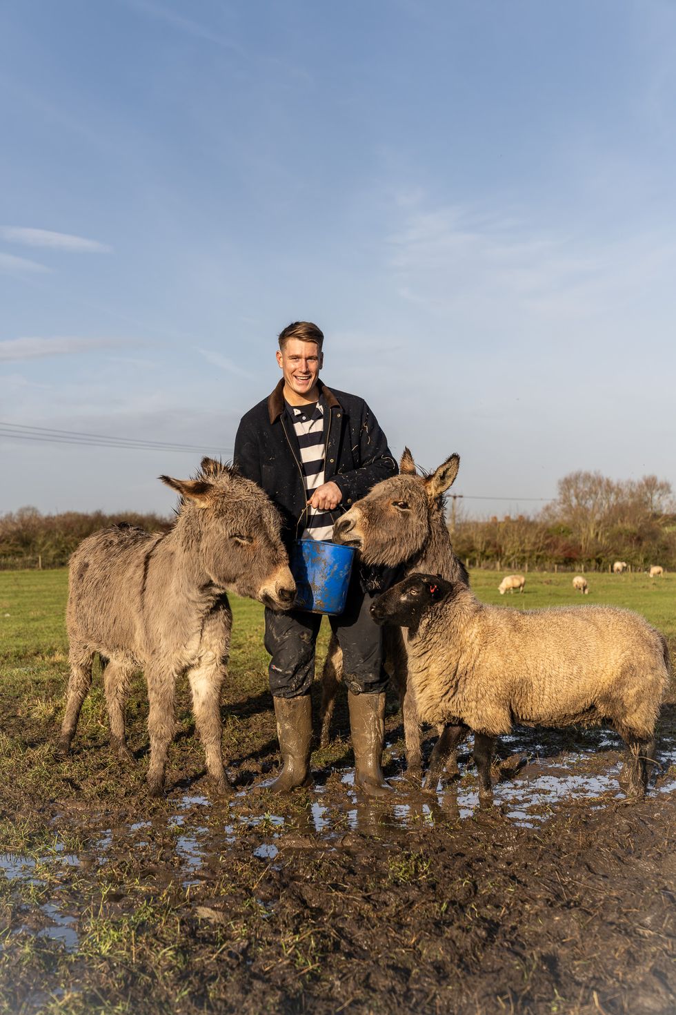 farmer stands next to a donkey