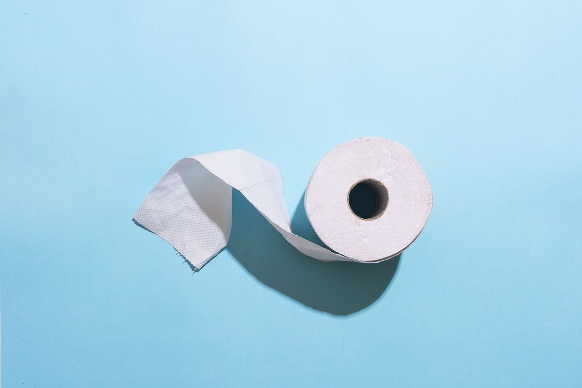roll of toilet paper against light blue background