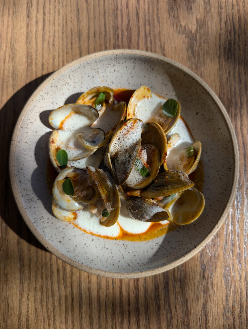 dish of clams garnished with herbs in a bowl