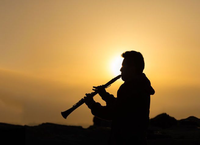 Sky, Silhouette, Musical instrument, Backlighting, Wind instrument, Woodwind instrument, Photography, Flute, Bagpipes, Sunset, 
