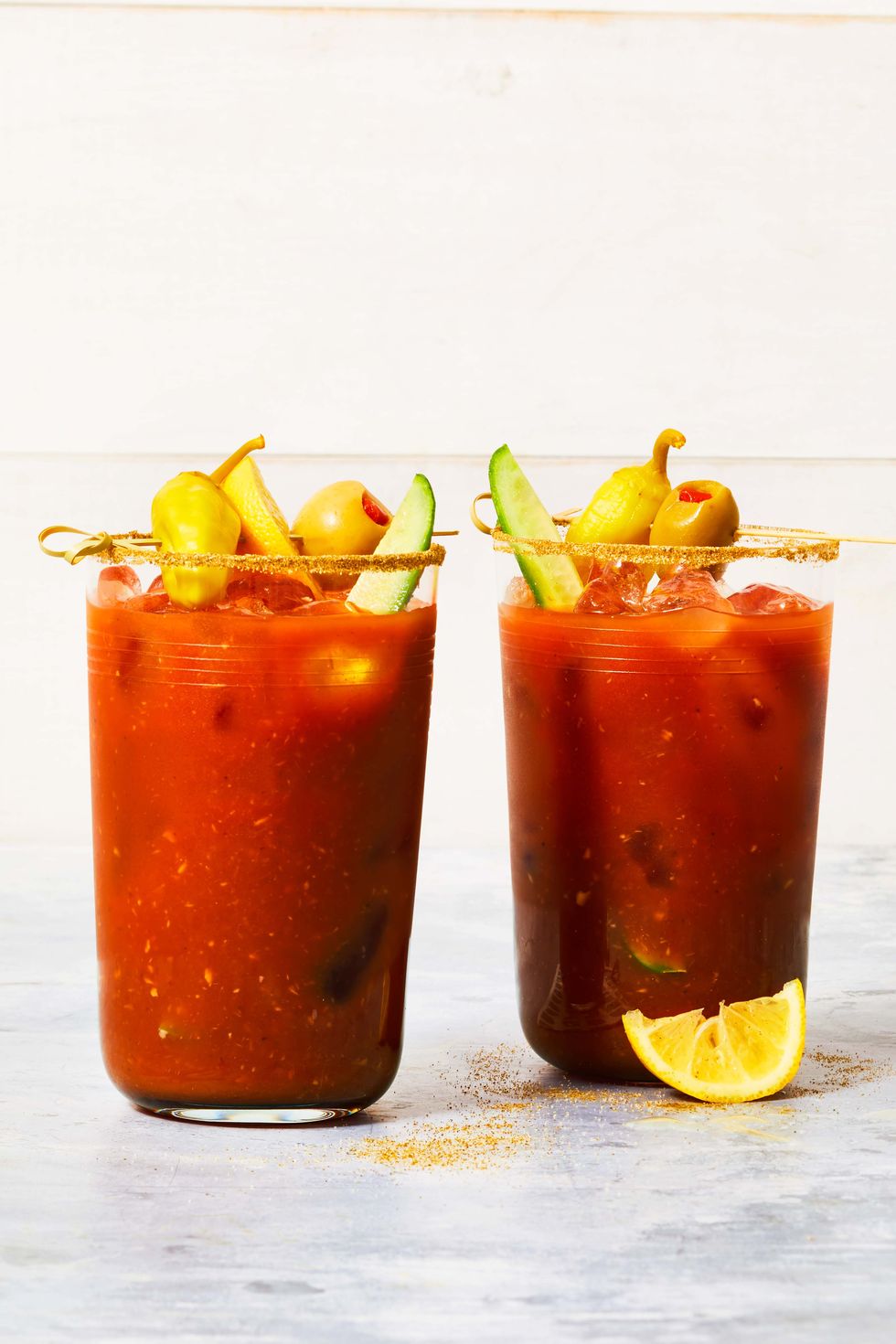 two bloody marys with garnishes on top