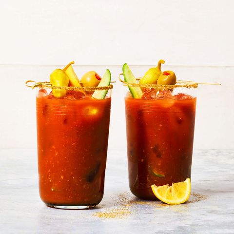 classic bloody marys on a marble surface with garnishes