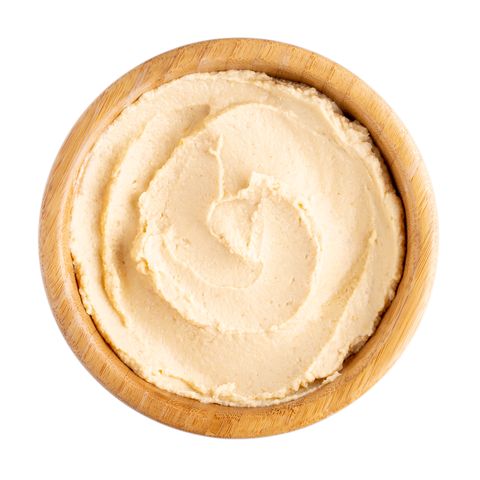 Classic chickpea hummus in wooden bowl isolated on white. Top view.