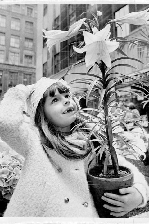 young girl carrying an easter lily
