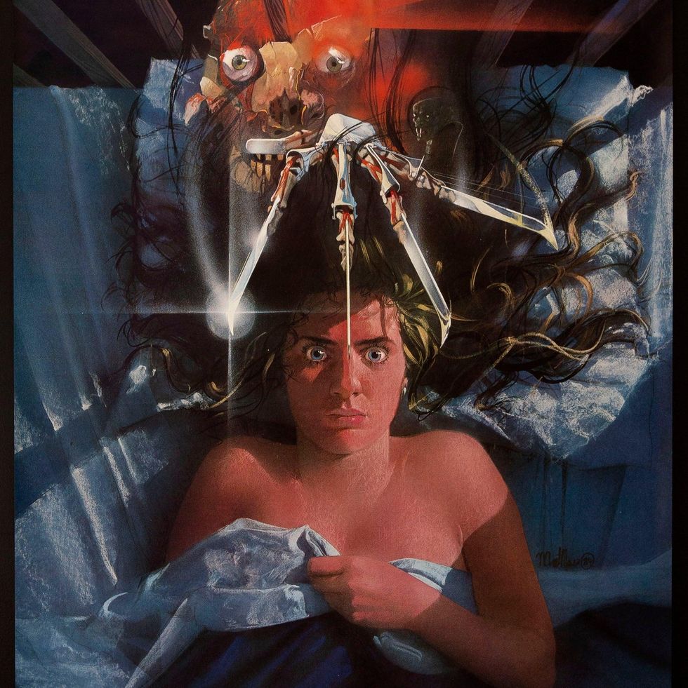 the poster for the classic horror movie a nightmare on elm street,  which features freddy krueger menacing a young woman in bed