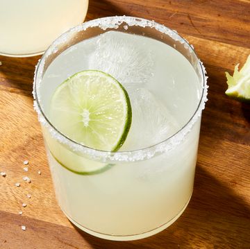 margaritas in a clear glass with a salt rim and lime garnish