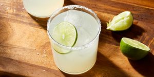 margaritas in a clear glass with a salt rim and lime garnish