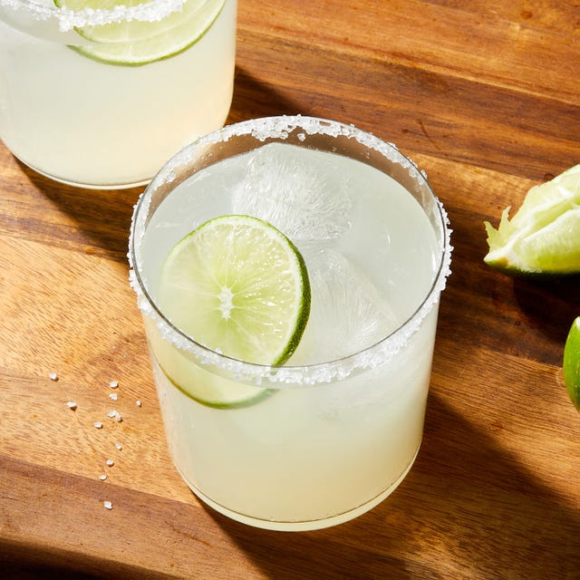 margaritas in a clear glass with a salt rim and lime garnish