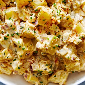 classic potato salad with pickles, onions, and topped with paprika and chives