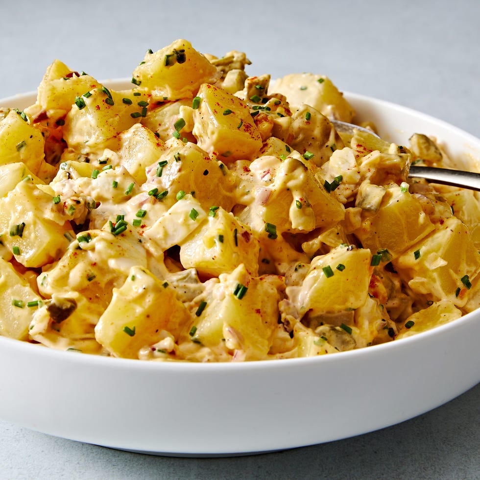 classic potato salad with pickles, onions, and topped with paprika and chives