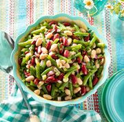 classic three bean salad in blue bowl with big spoon and flowers