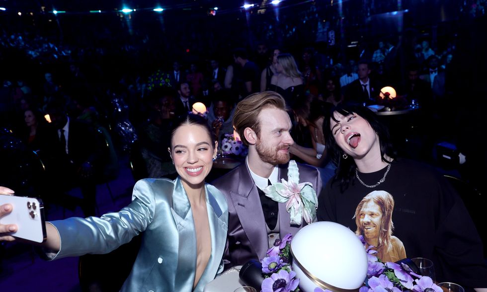 claudia sulewski taking a photo of herself, finneas, and billie eilish at the grammy awards