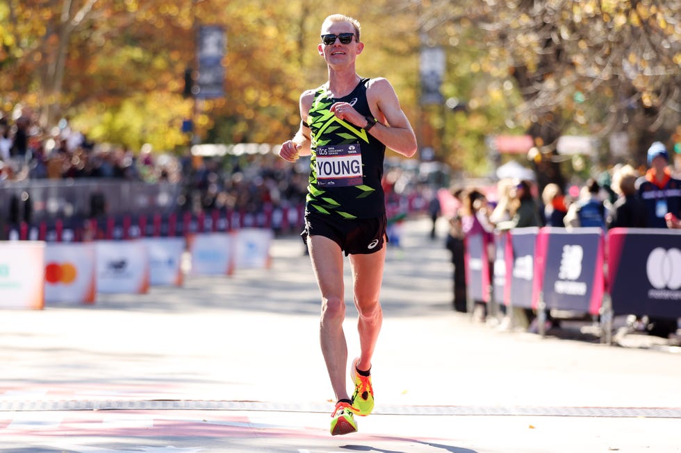 a runner crosses the finish line at a marathon