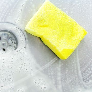 cleaning a sink with yellow sponge